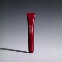 Red skincare tube with brand name on a gray background