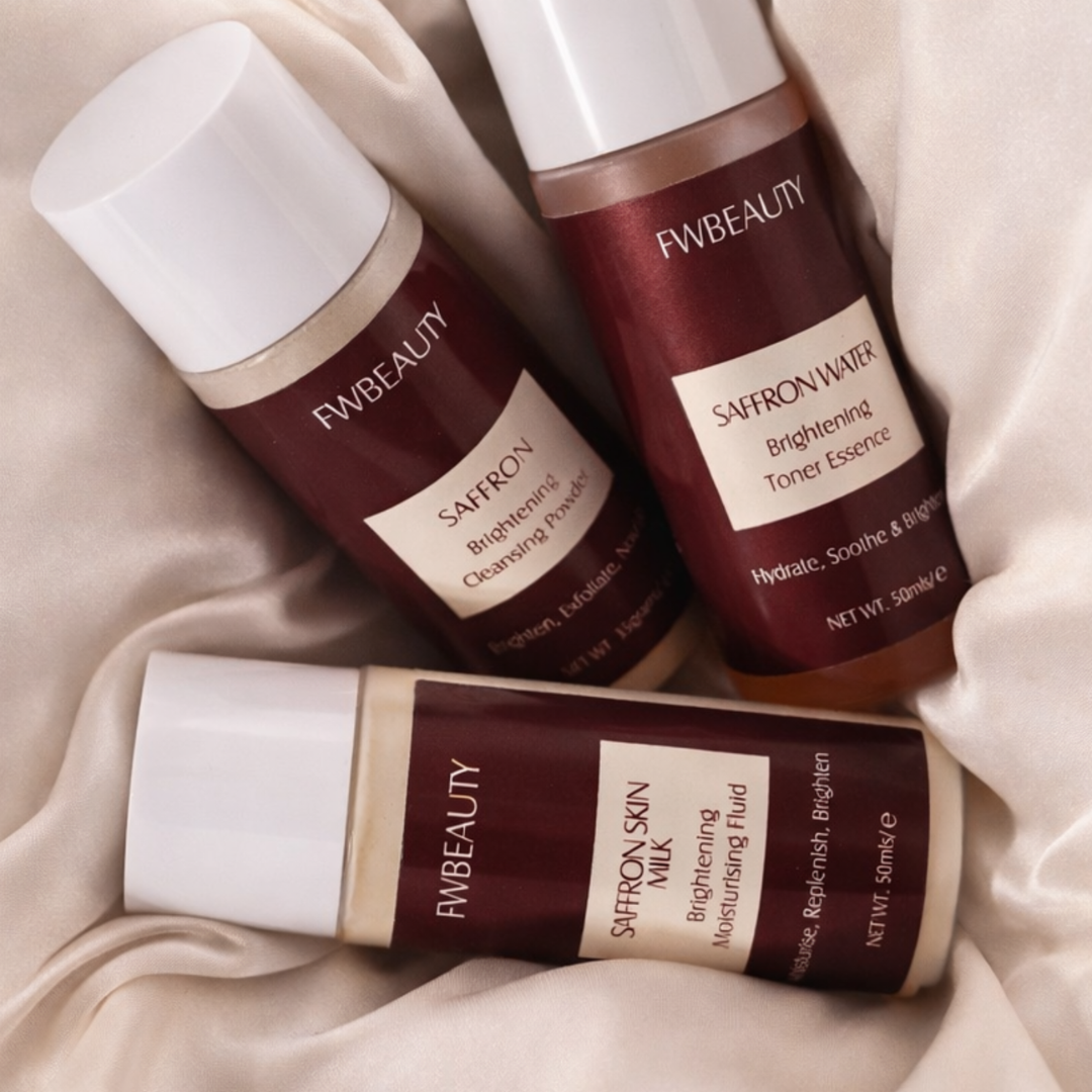 Three bottles of FW Beauty skincare products on a beige fabric background