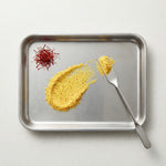 Metal tray with saffron and turmeric on a white background